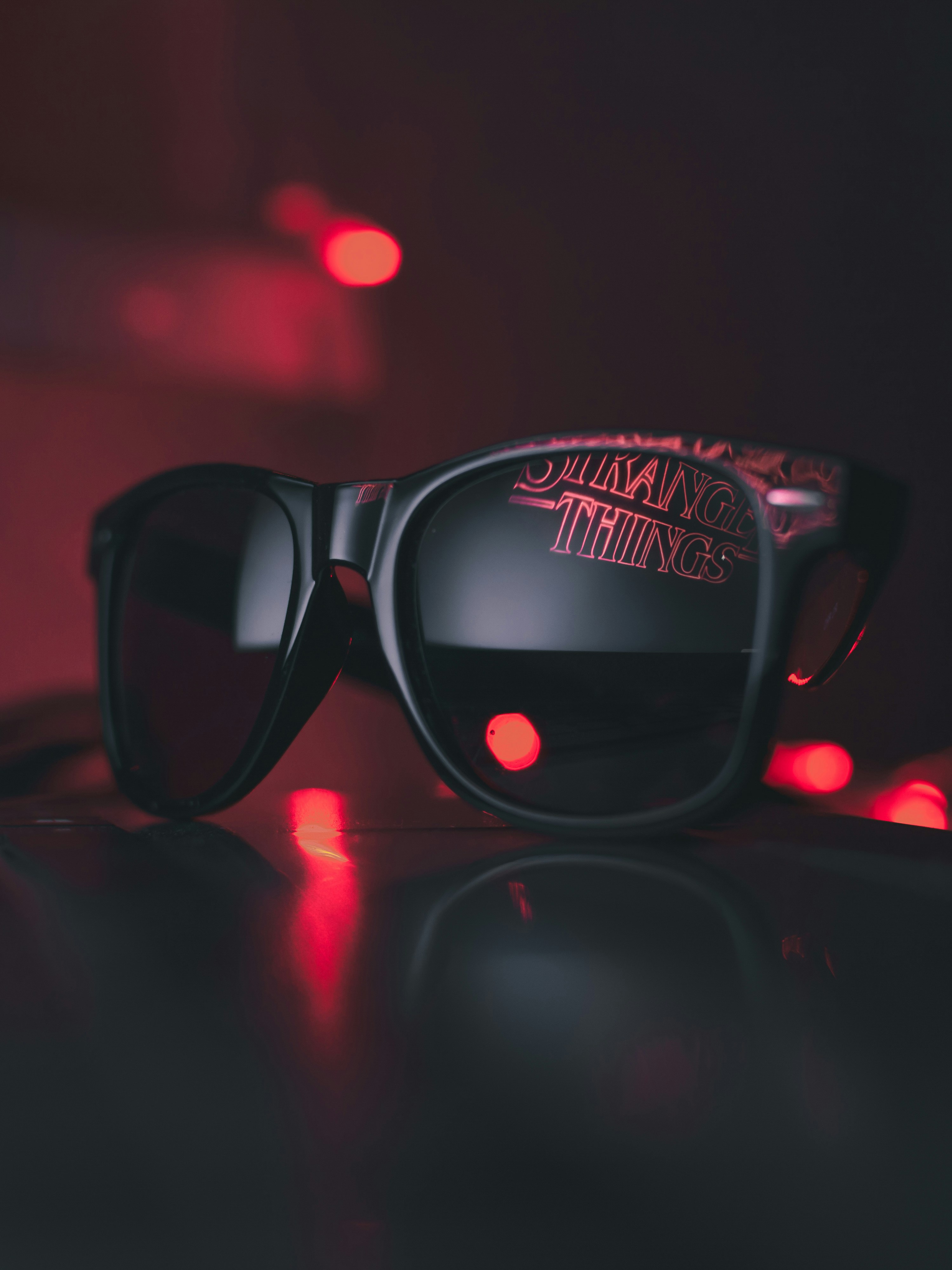 Sunglasses with the logo for Stranger Things reflected in the lens