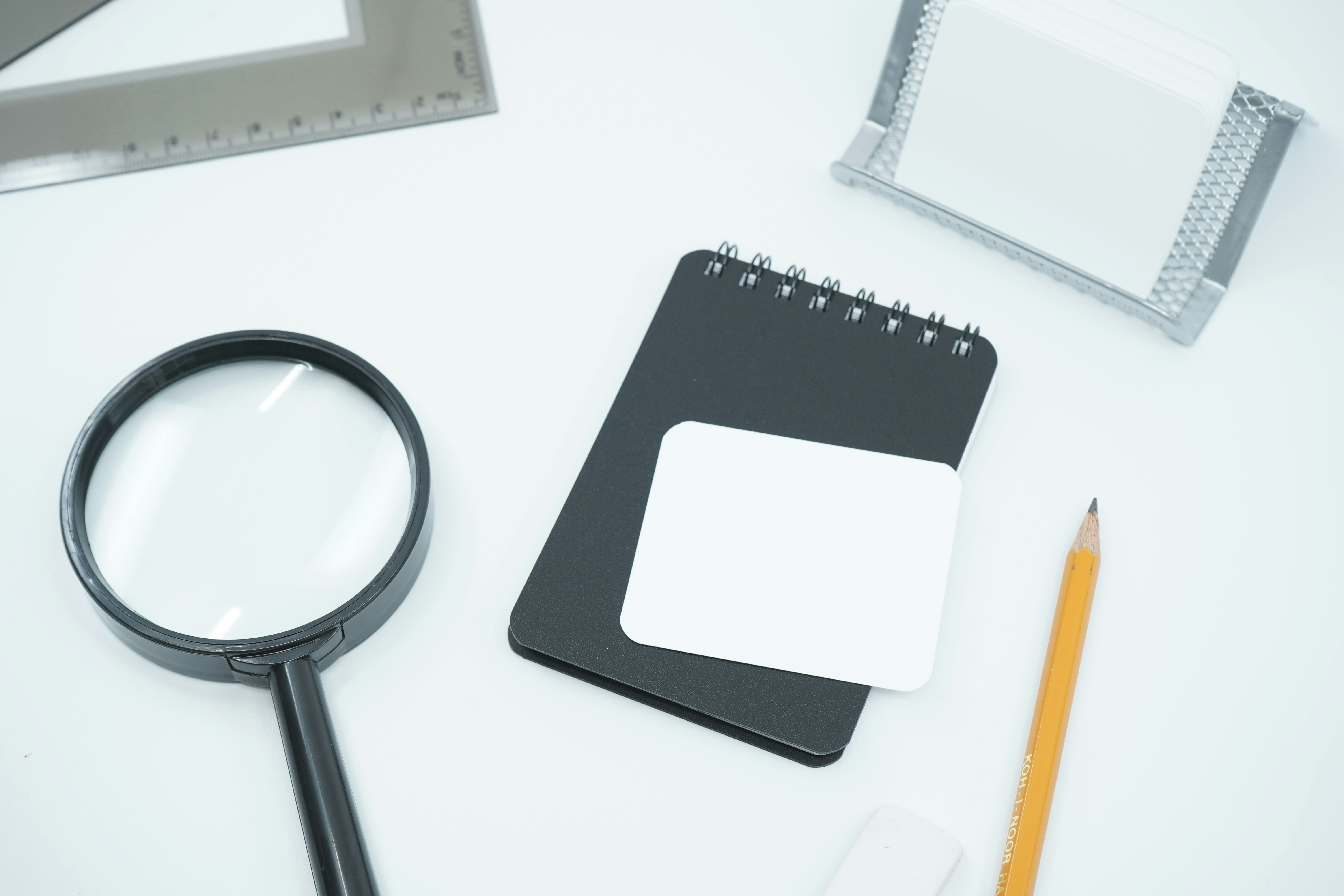 Notepad, pencil and magnifying glass